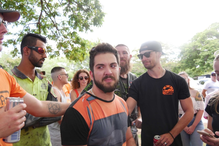 Dean Gieszler looks slightly to the left as he stands in a crowd of people. He appears to have tears in his eyes.