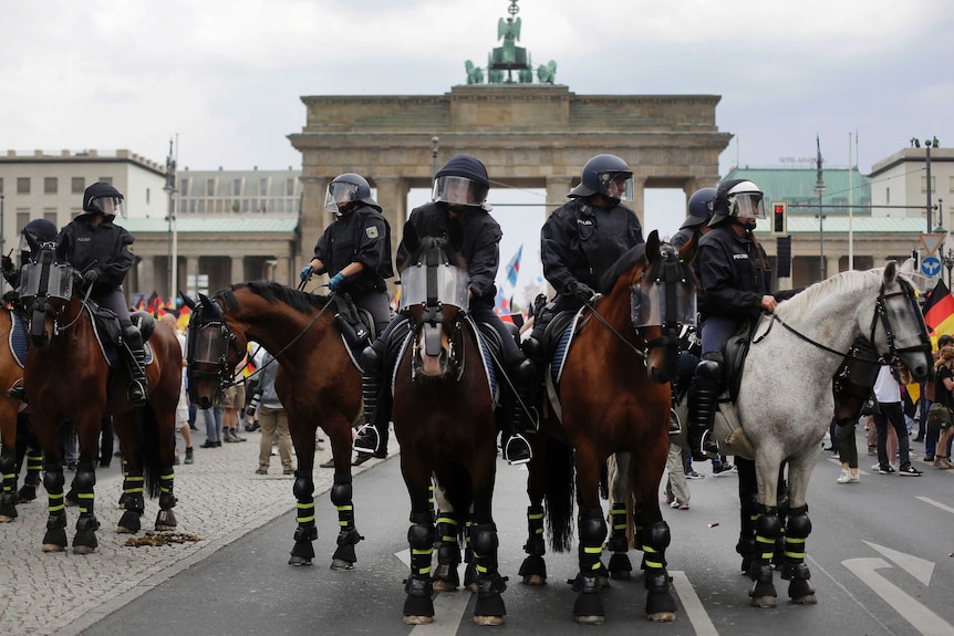 Police on horses gather in front of the Brandenburg Gate in Berlin.