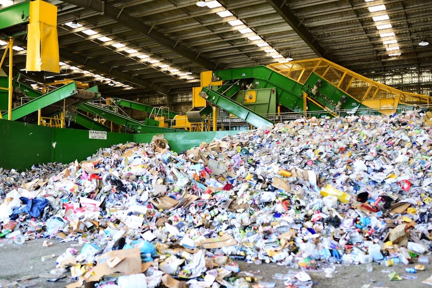 A large pile of rubbish at a recycling facility.