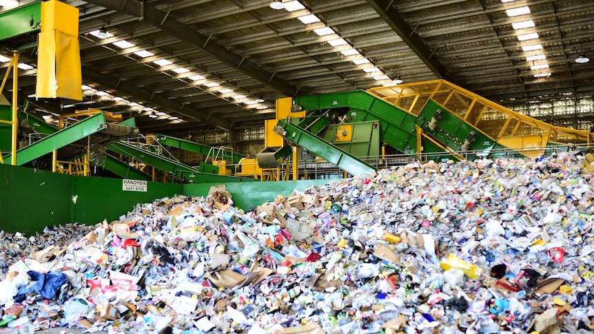 A large pile of rubbish at a recycling facility.