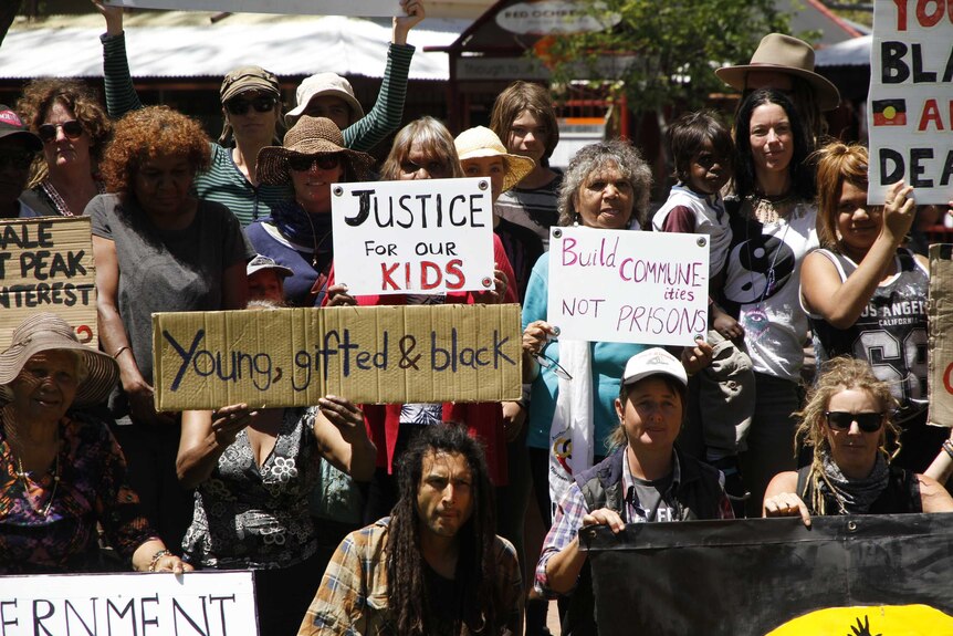 Protesters hold placards in Alice Springs.