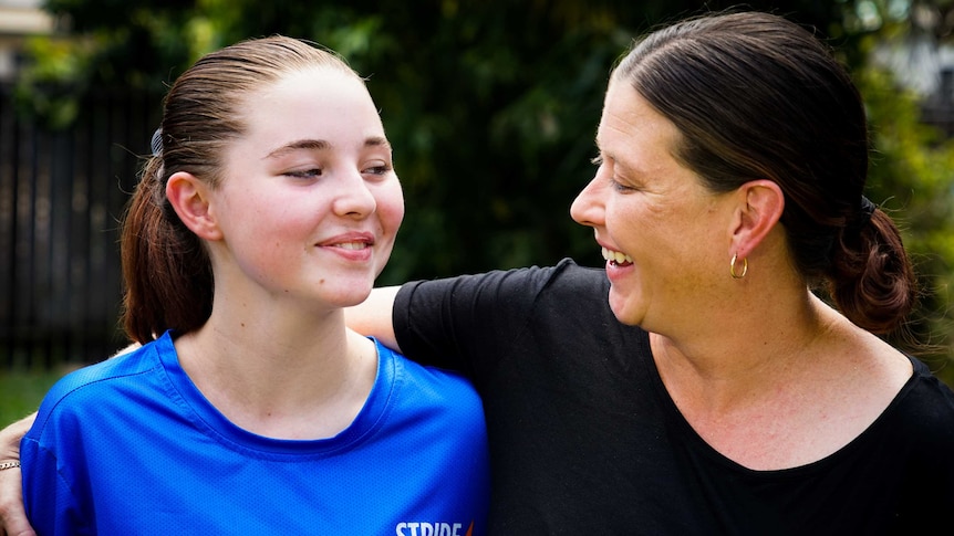 Megan is wearing a black shirt and smiling warmly at her daughter Kaylah.