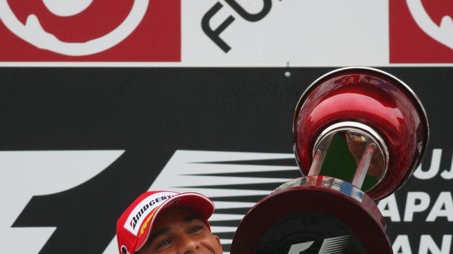 British McLaren-Mercedes driver Lewis Hamilton celebrates on the podium
