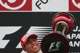 British McLaren-Mercedes driver Lewis Hamilton celebrates on the podium