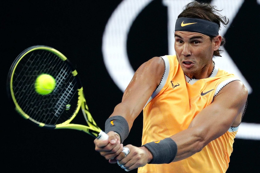 Tennis player hits a backhand on Rod Laver Arena.