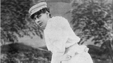 Nellie Gregory poses with a cricket bat at the Sydney Cricket Ground, wearing a white outfit and cap.