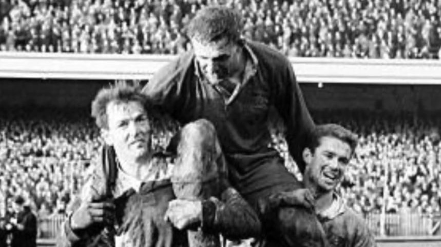 A black-and-white image of a rugby union captain on the shoulders of teammates
