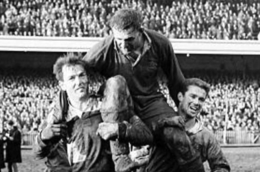 A black-and-white image of a rugby union captain on the shoulders of teammates