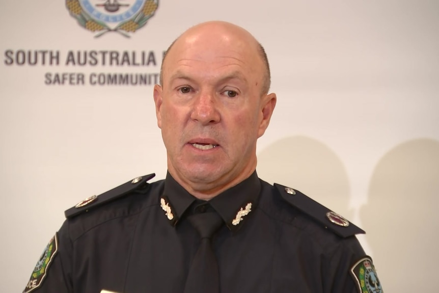 A middle-aged police officer addresses the media.