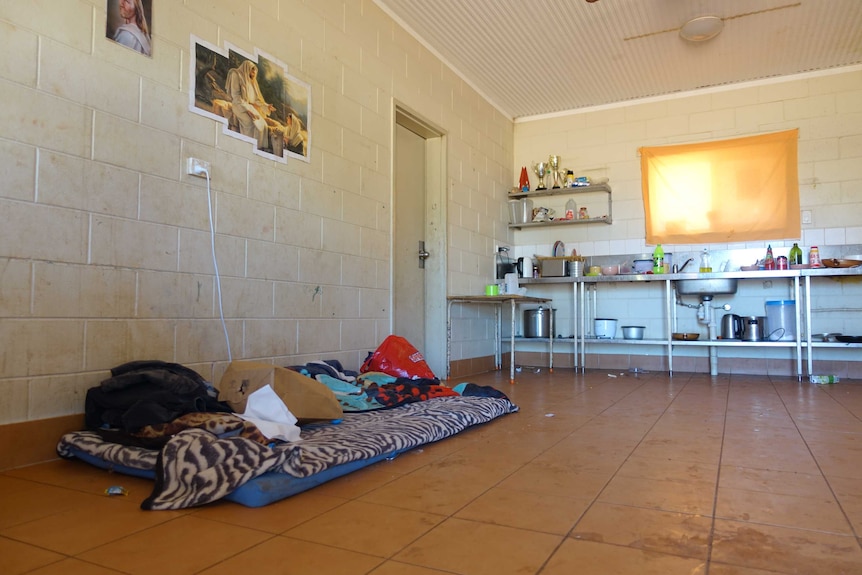 A mattress sits on the tiled floor of a basic home.