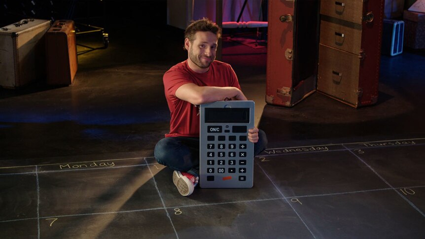 Man sits on floor with giant calculator