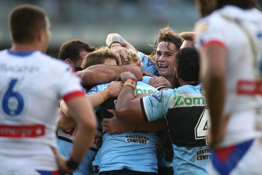 Cronulla Sharks get around Aiden Tolman after a try against the Newcastle Knights.