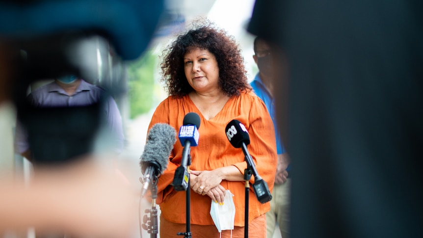 NT Senator Malarndirri McCarthy standing in front of several microphones and speaking at a press conference.