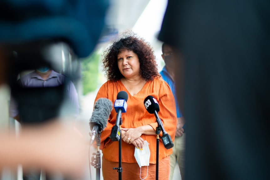 NT Senator Malarndirri McCarthy standing in front of several microphones and speaking at a press conference.