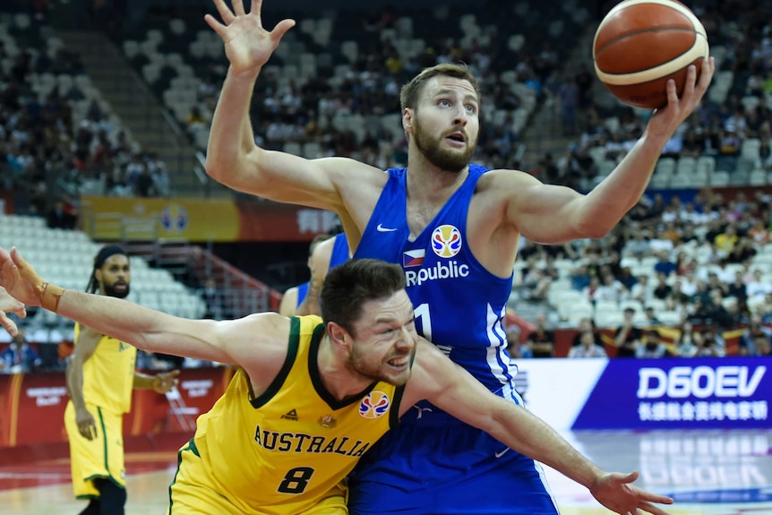 Two players fight for a basketball during a game.