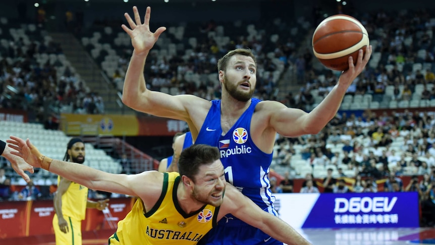 Two players fight for a basketball during a game.