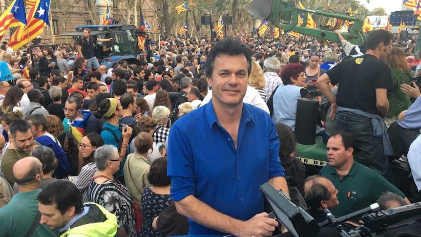 Steve standing in front of huge flag-waving crowd of separatists.