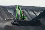 a green digger pictured in an open-cut coal mine.