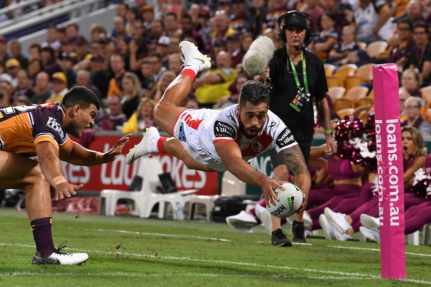 Jordan Pereira dives in mid-air as he tries to ground the ball with his right hand.