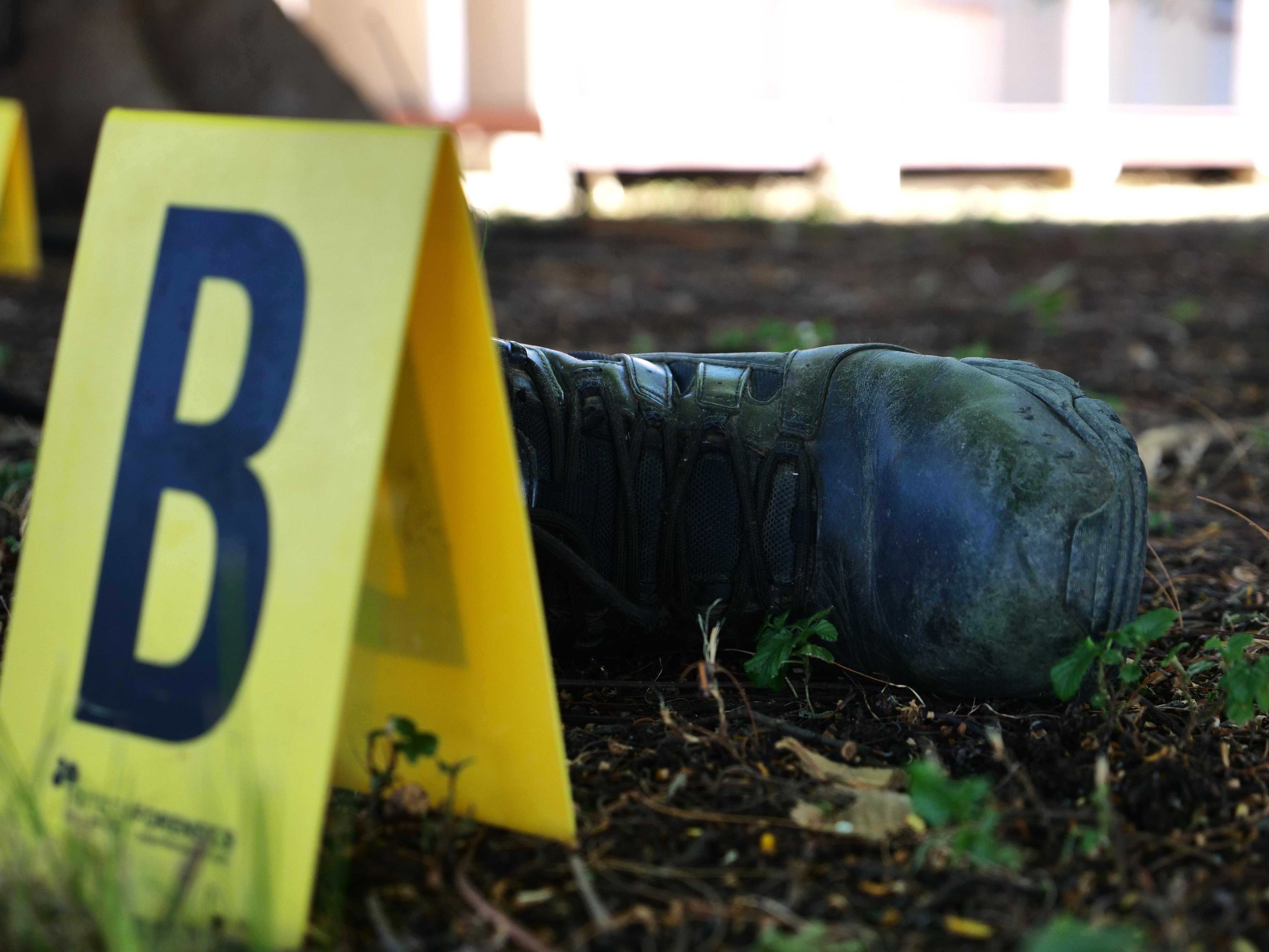 A crime scene letter B on the ground with a boot behind it. 