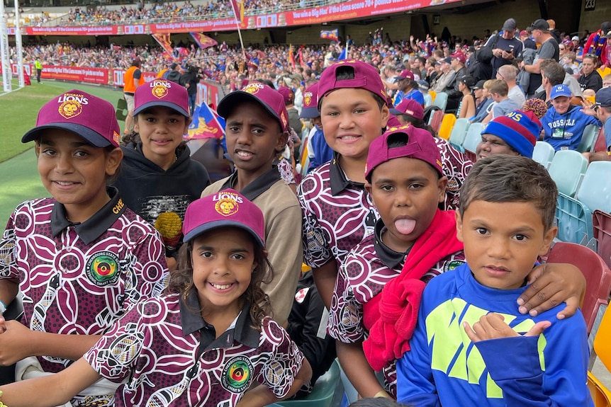 Cherbourg Indigenous kids in uniforms and Lions caps at the Gabba