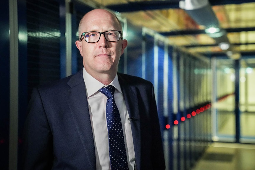 Simon Cooper stands among servers in a data centre.