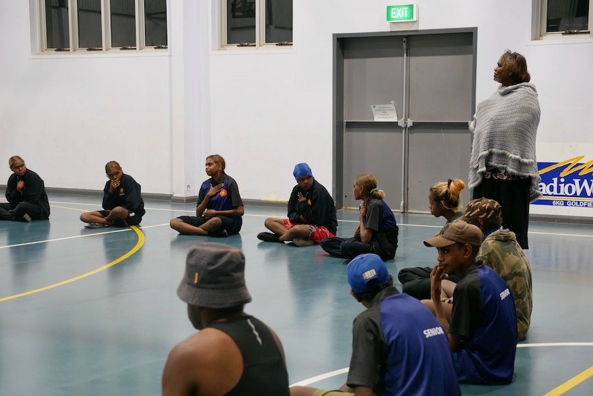 A group of children sitting on the floor in a circle 