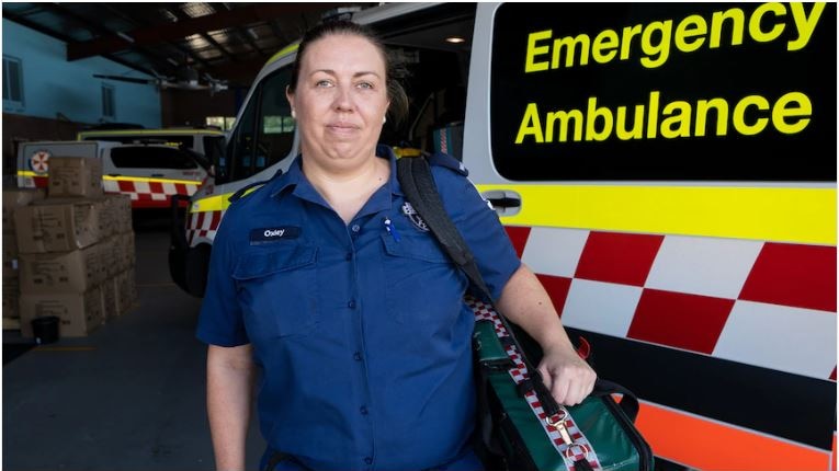 a female paramedic standing next to an ambulance