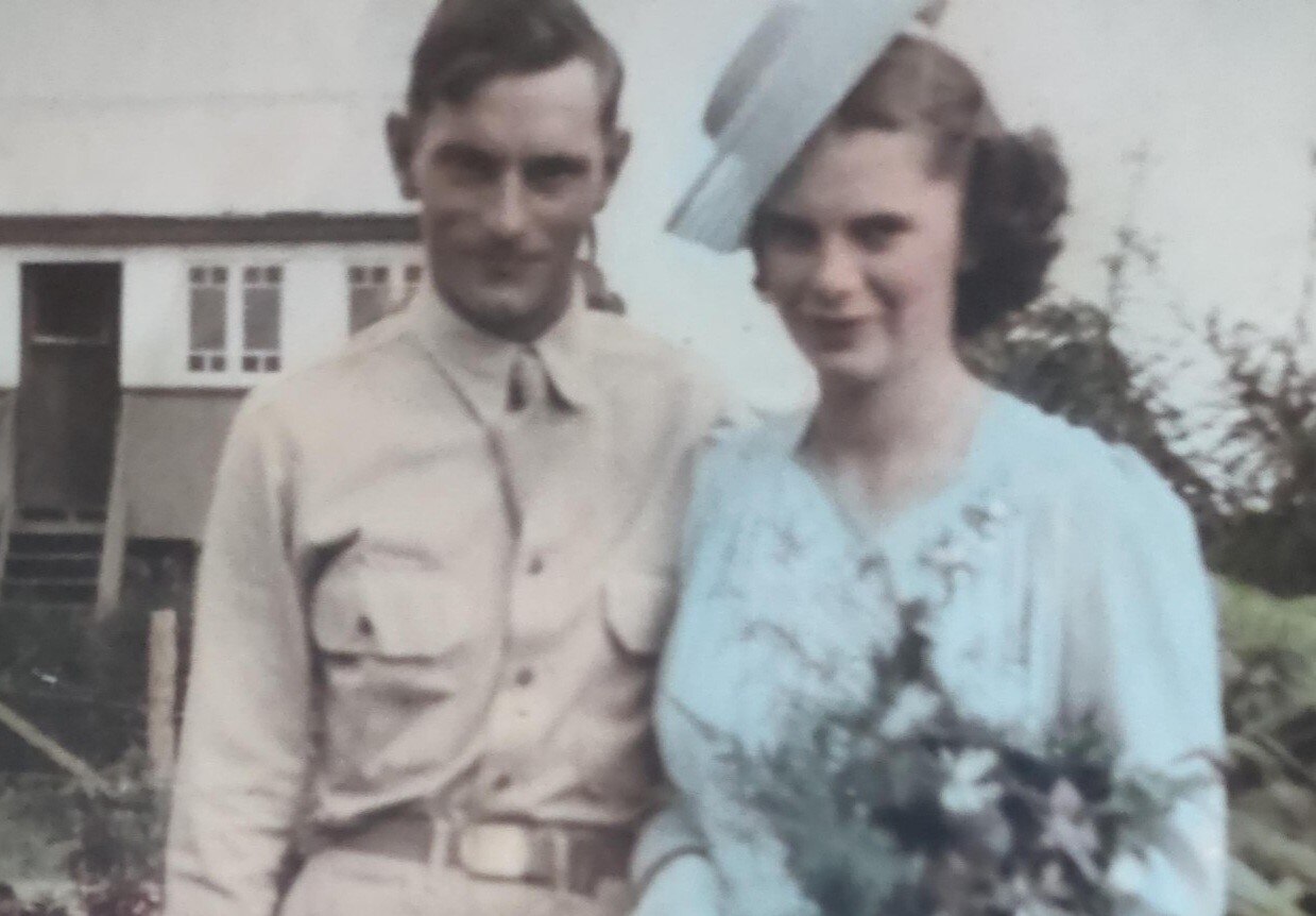Sepia coloured photo of army man and bride is pastel blue
