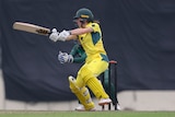 An Australia cricketer plays a cut shot during a match against Bangladesh