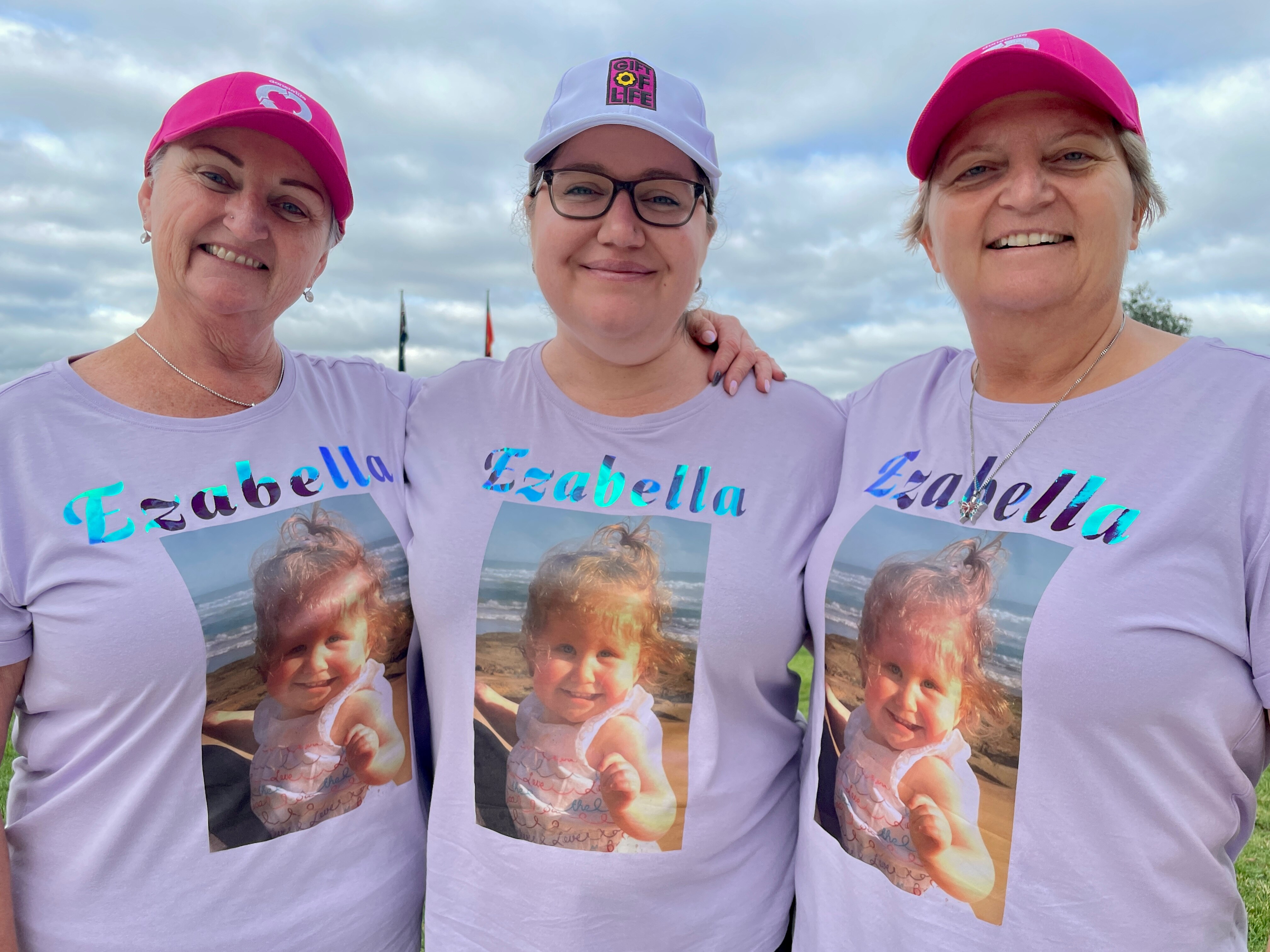 Mum Naomi Wilson (centre) with family taking part in the 2024 Gift of Life Walk, wearing shirts with a photo of Ezabella. 