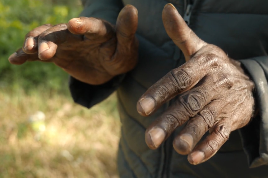 A close-up shot of an Indigenous man's hands.