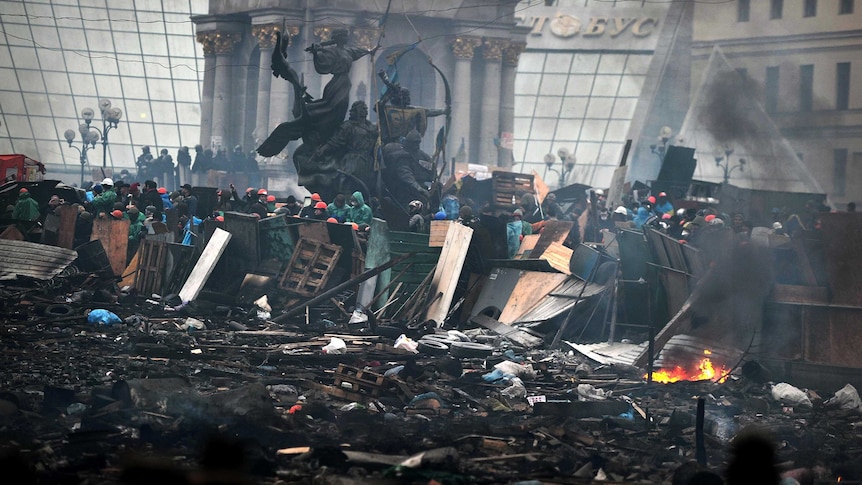 Anti-government protestors stand behind the barricades at Independence Square in Kiev.