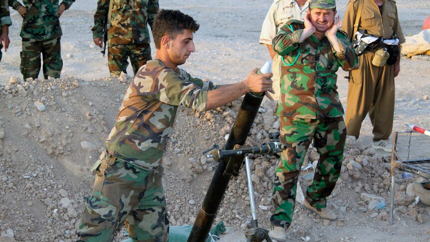 Kurdish Peshmerga forces fire a mortar near Amerli