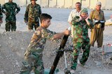 Kurdish Peshmerga forces fire a mortar near Amerli