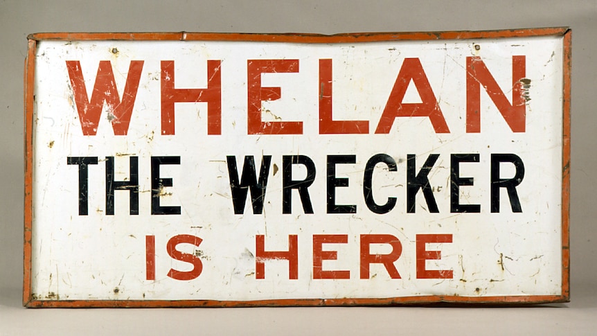 A red and white sign that says Whelan the Wrecker is here