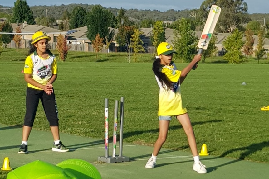 A girl practices batting at a cricket pitch