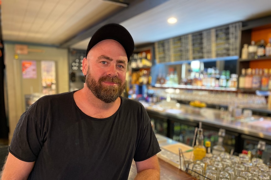 El hombre con un sombrero negro se encuentra casualmente en un bar. 