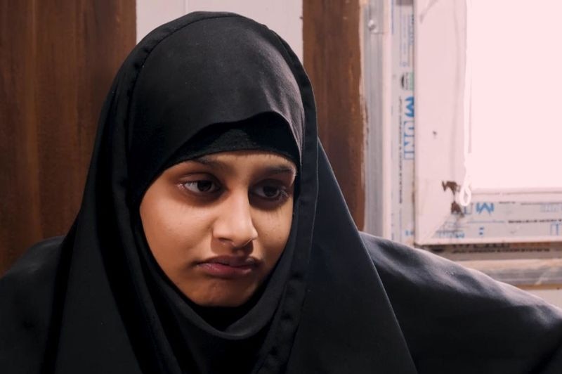 A woman wearing Islamic religious attire looks away from the camera during an interview.