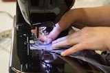 Hands using a sewing machine