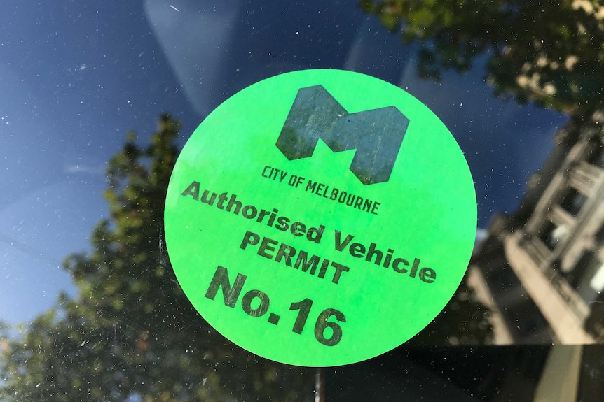 A green authorised vehicle permit sticker on a car window from the City of Melbourne.