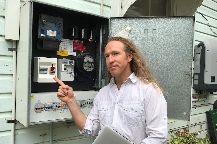 Mobius Barnaby points out the smart electricity meter that gives real-time feedback on energy use