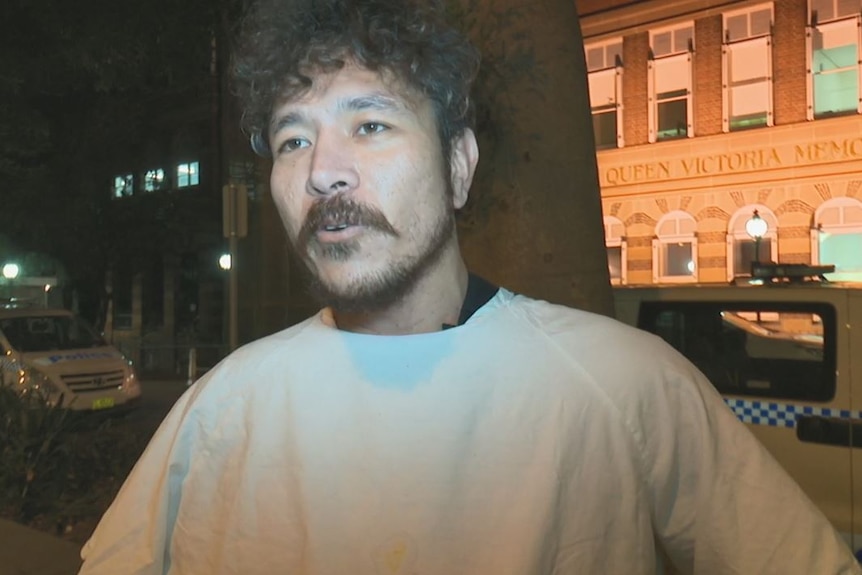 man in gown outside hospital during evening