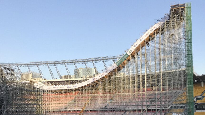 A large scaffolding structure with snow on top of it in a stadium.