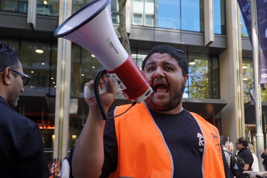 A man shouting into a loud speaker