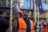 A man shouting into a loud speaker