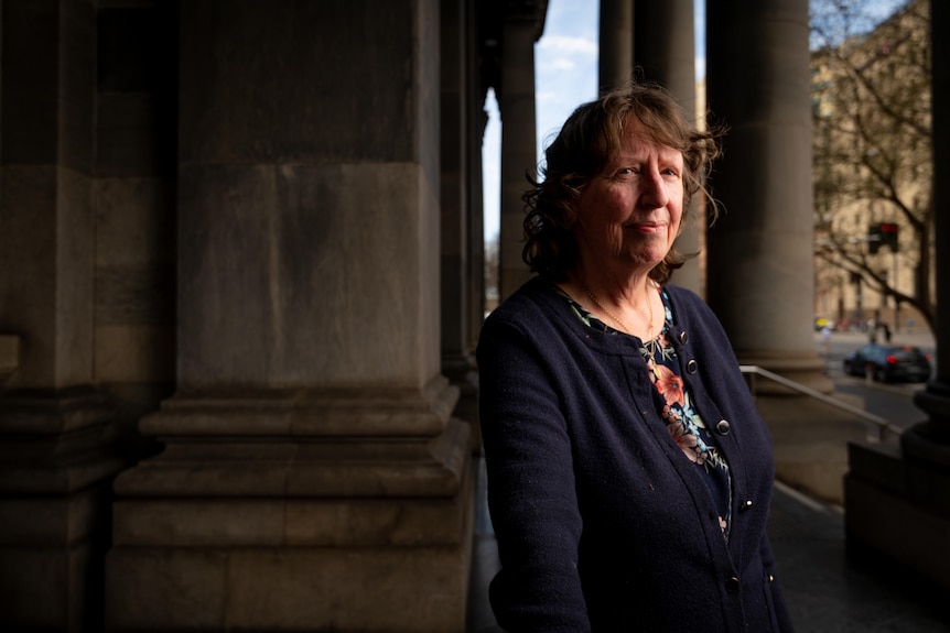 Sharon Lawn standing side on with the pillars of parliament in the background