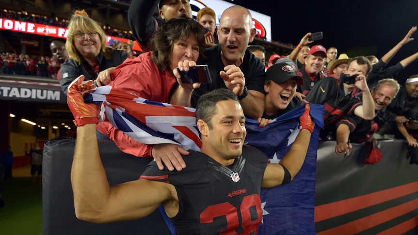 Jarryd Hayne poses with fans holding an Australian flag in San Francisco.