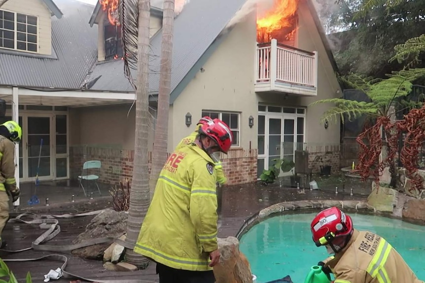Firefighters battle a blaze at a house