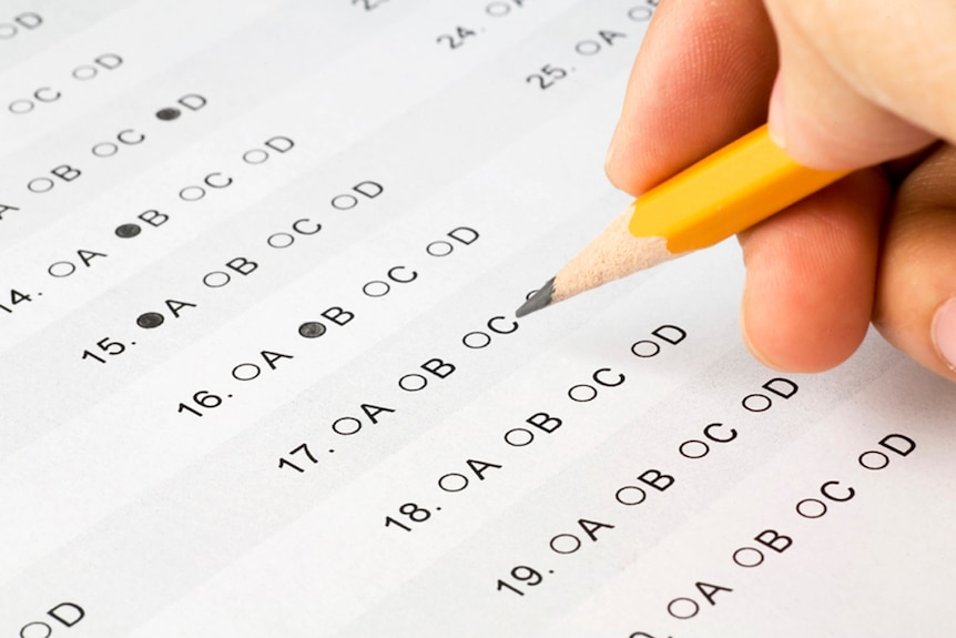 A student completes an exam paper.